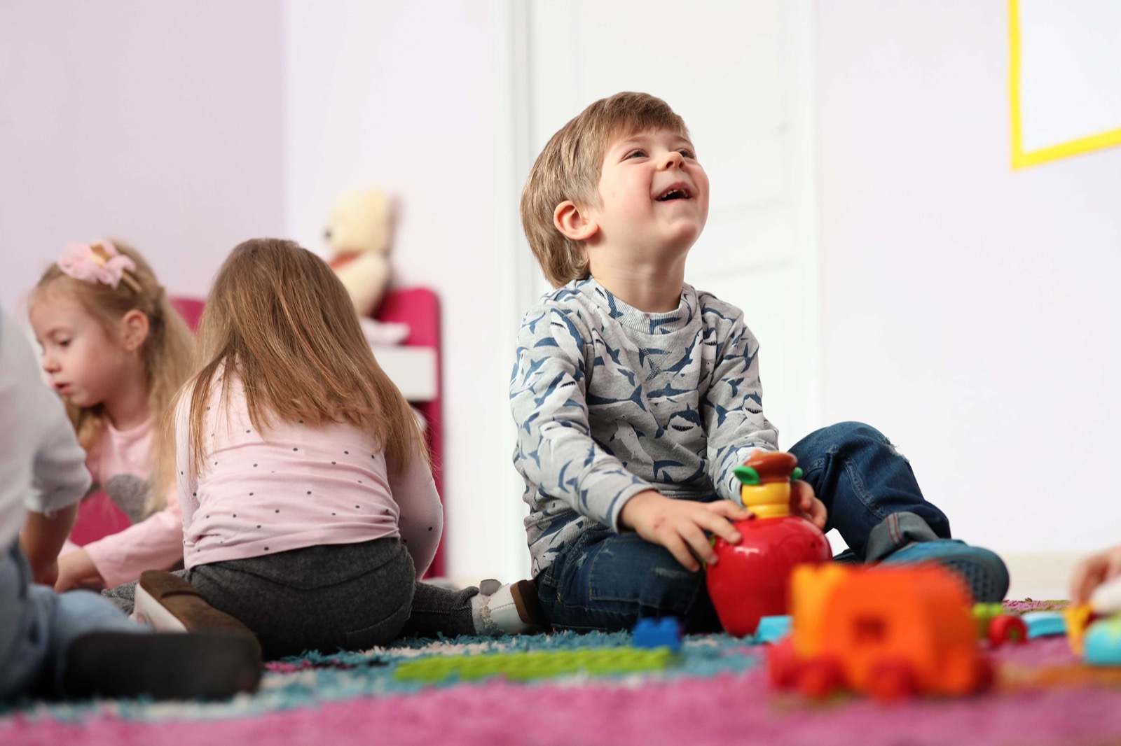 A child laughing while playing on the floor
