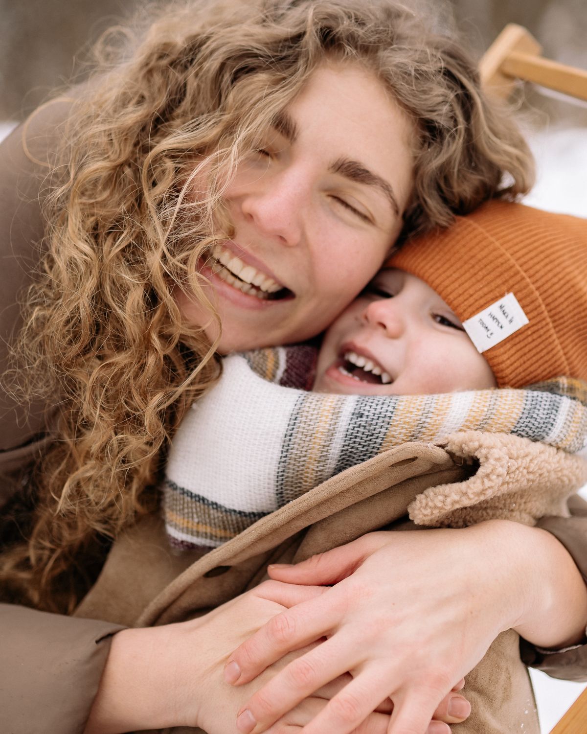 A parent and child holding each other close and laughing together